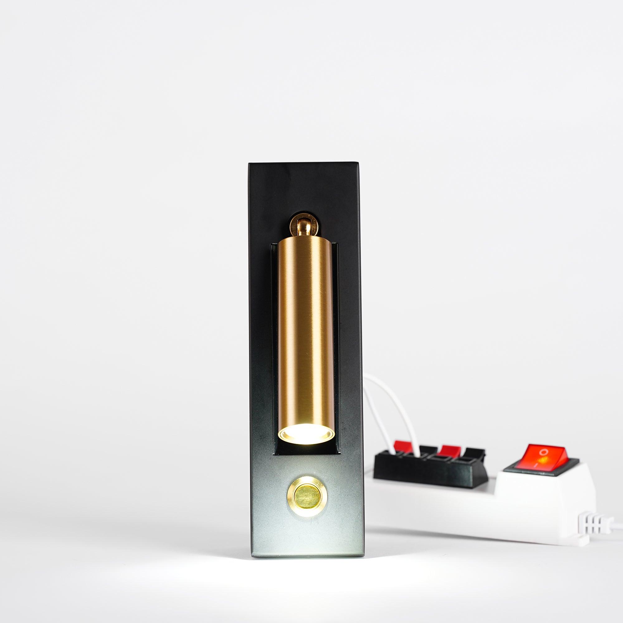 Modern wall-mounted light fixture with gold cylindrical design on a white background