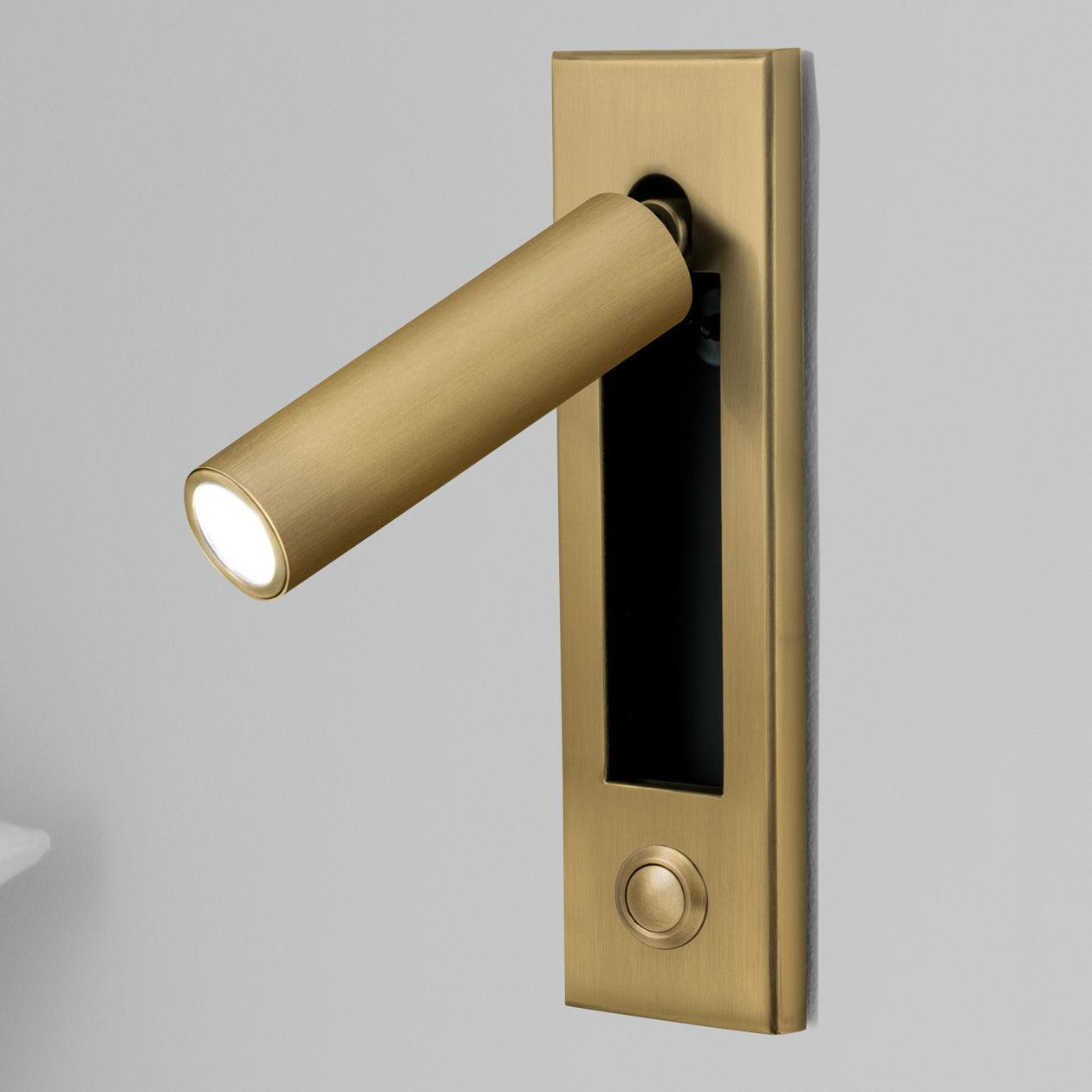 Brass door handle with integrated light on a gray background