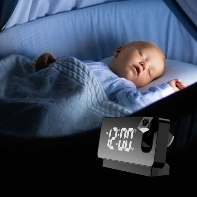 Baby sleeping in a crib with a digital clock showing the time.