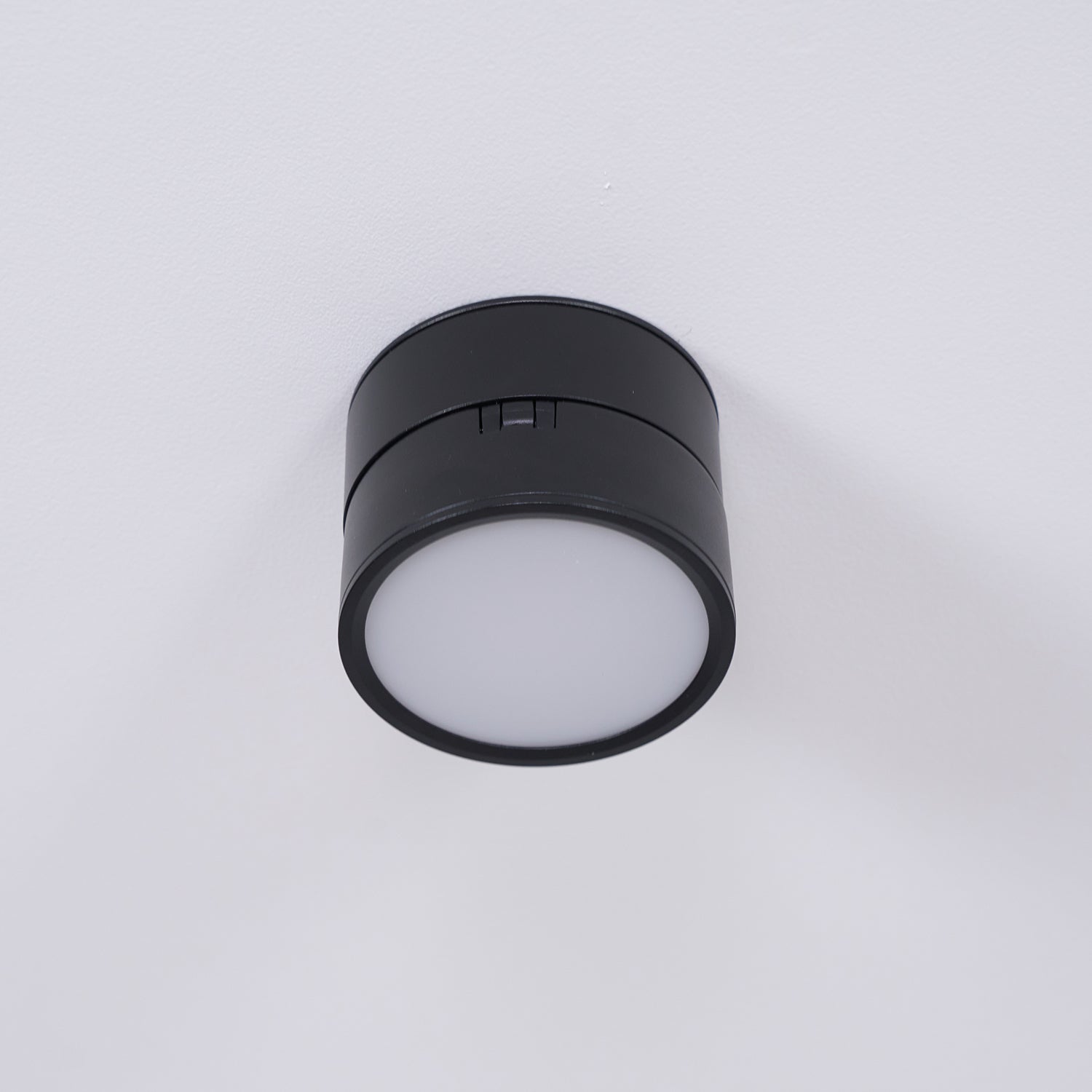 Black cylindrical light fixture on a white background