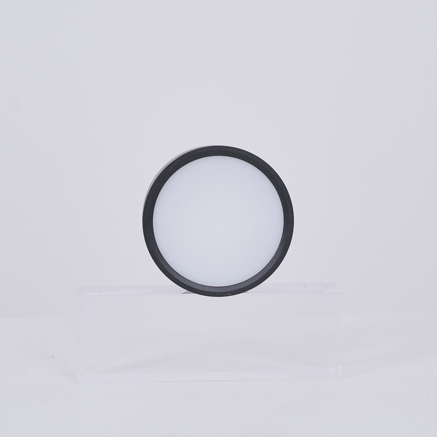 Black circular lamp on a light gray background
