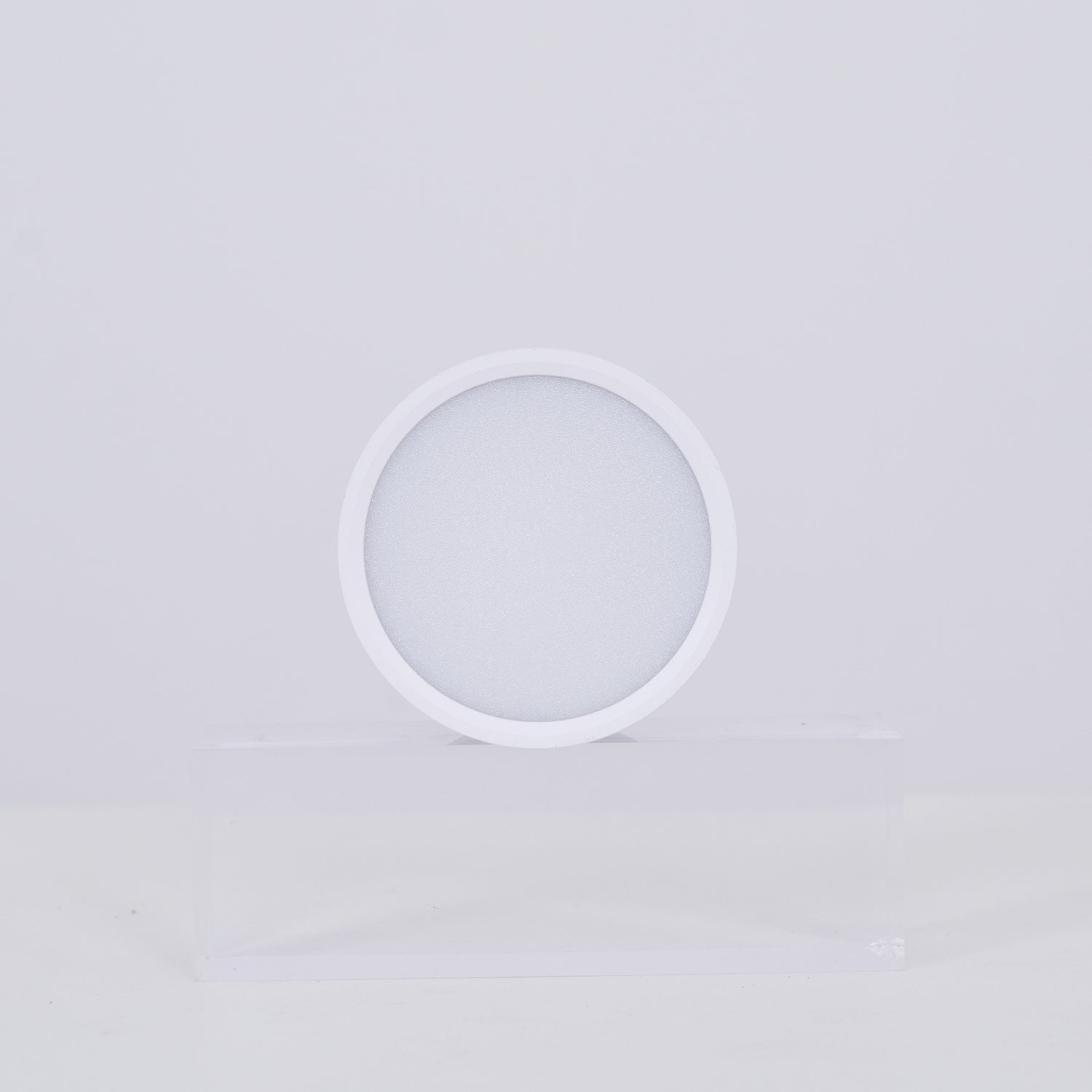 White circular lamp on a light gray background