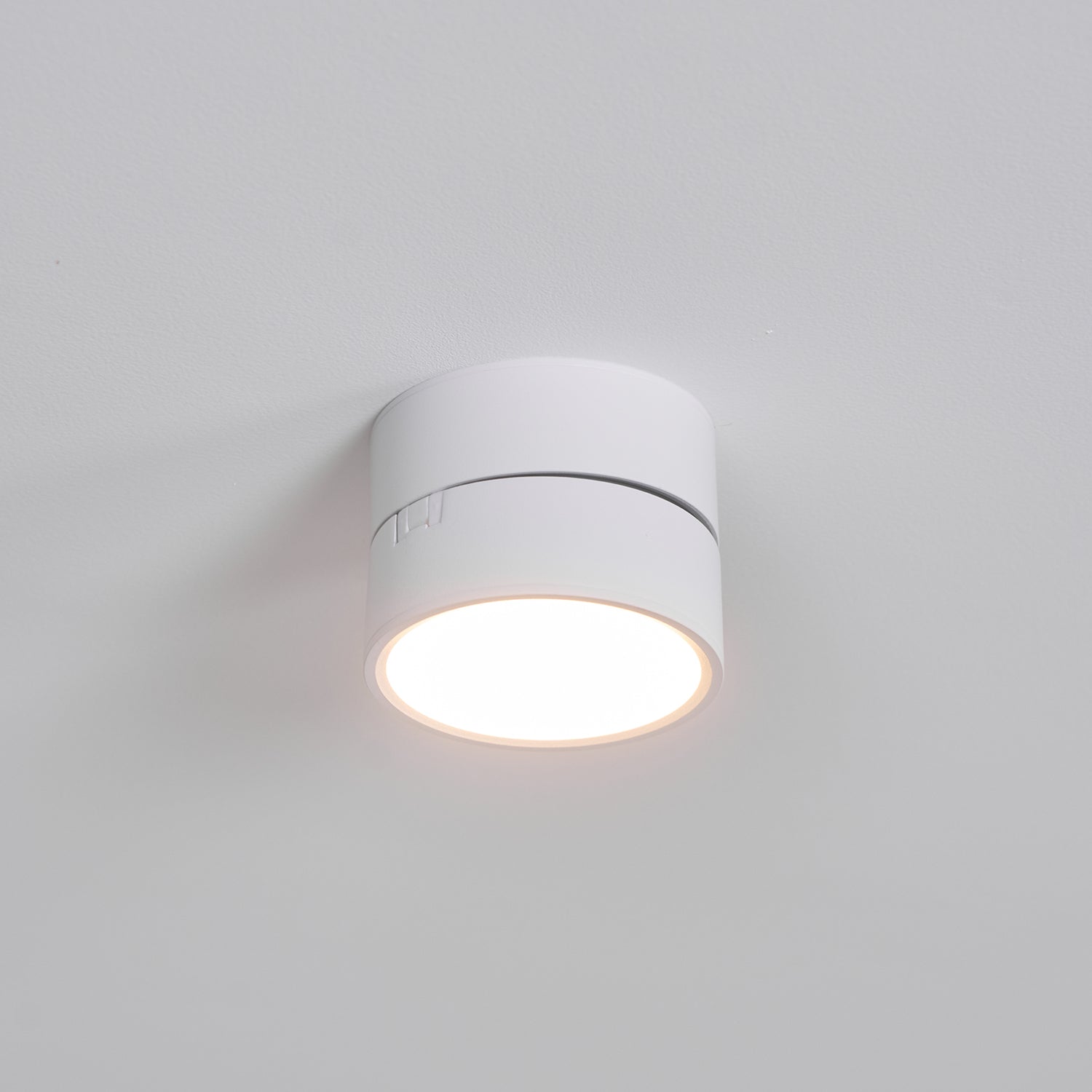 Round white ceiling light fixture on a plain gray background