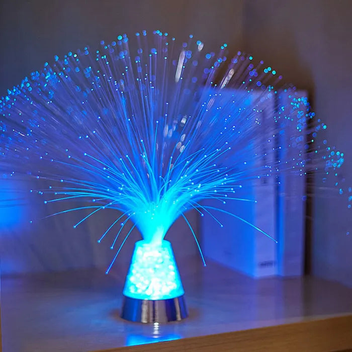 Fiber optic light with blue and green strands on a reflective surface