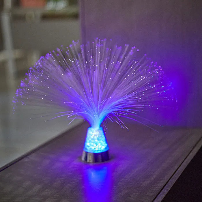 Fiber optic light emitting a purple and blue glow on a reflective surface.