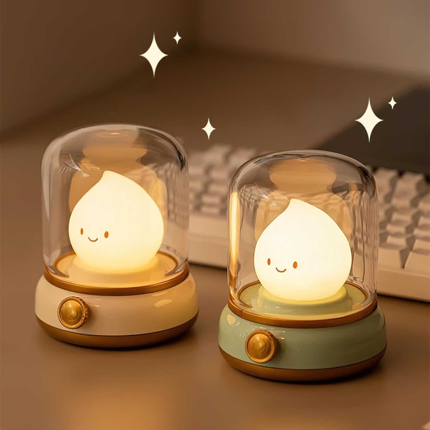 Two cute night lights with smiling faces under glass domes on a wooden surface.