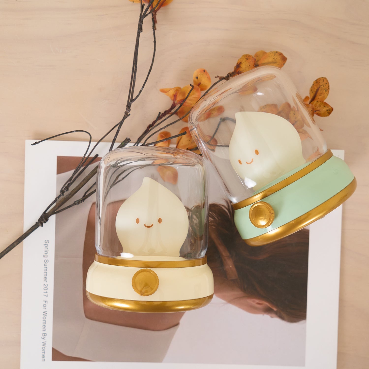 Two cute lamp characters in glass domes on a neutral background