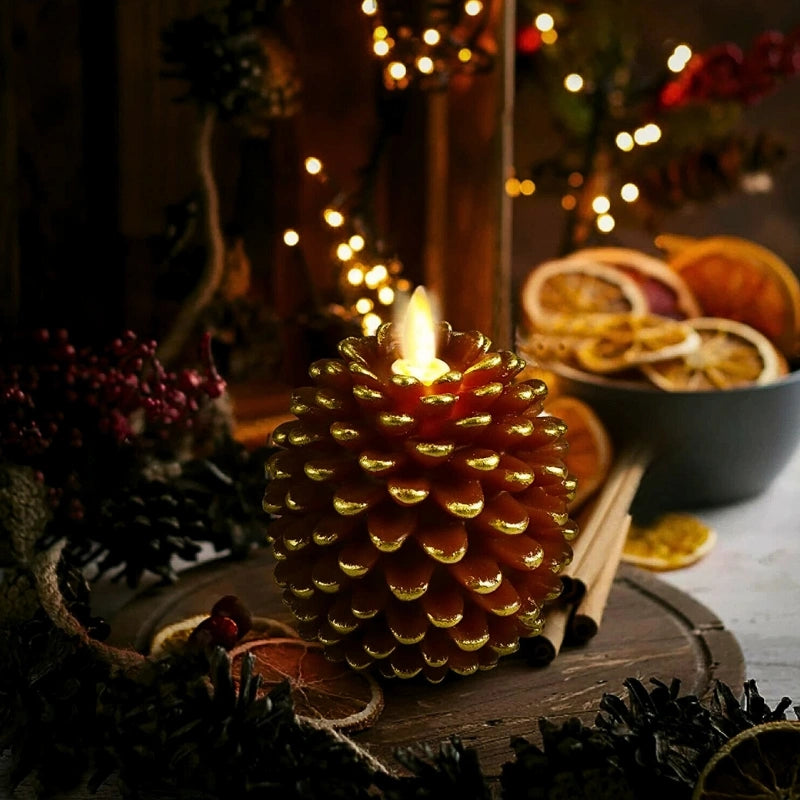 Decorative pinecone candle with a warm glow, surrounded by festive elements on a wooden surface.