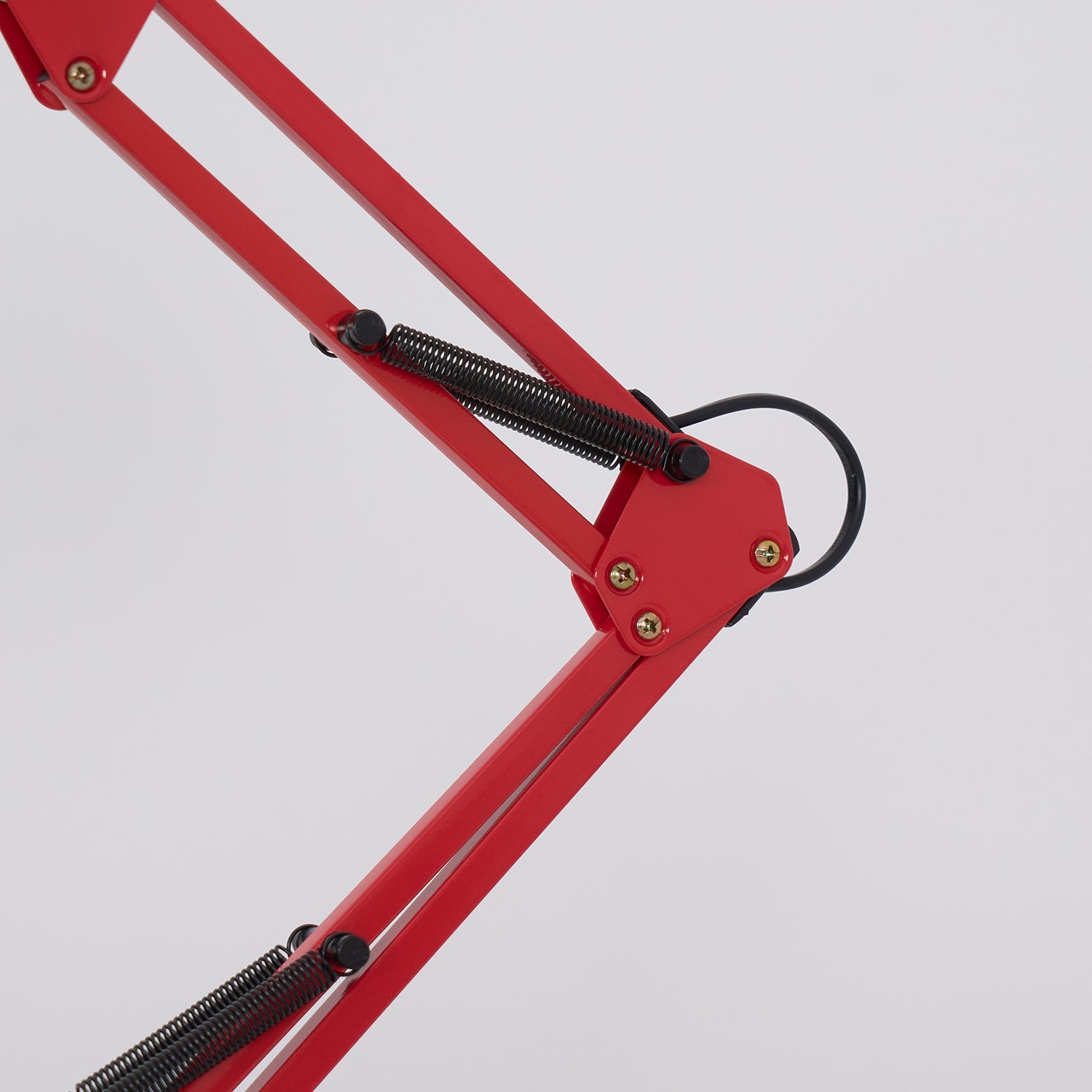 Red metal frame with black springs on a light gray background