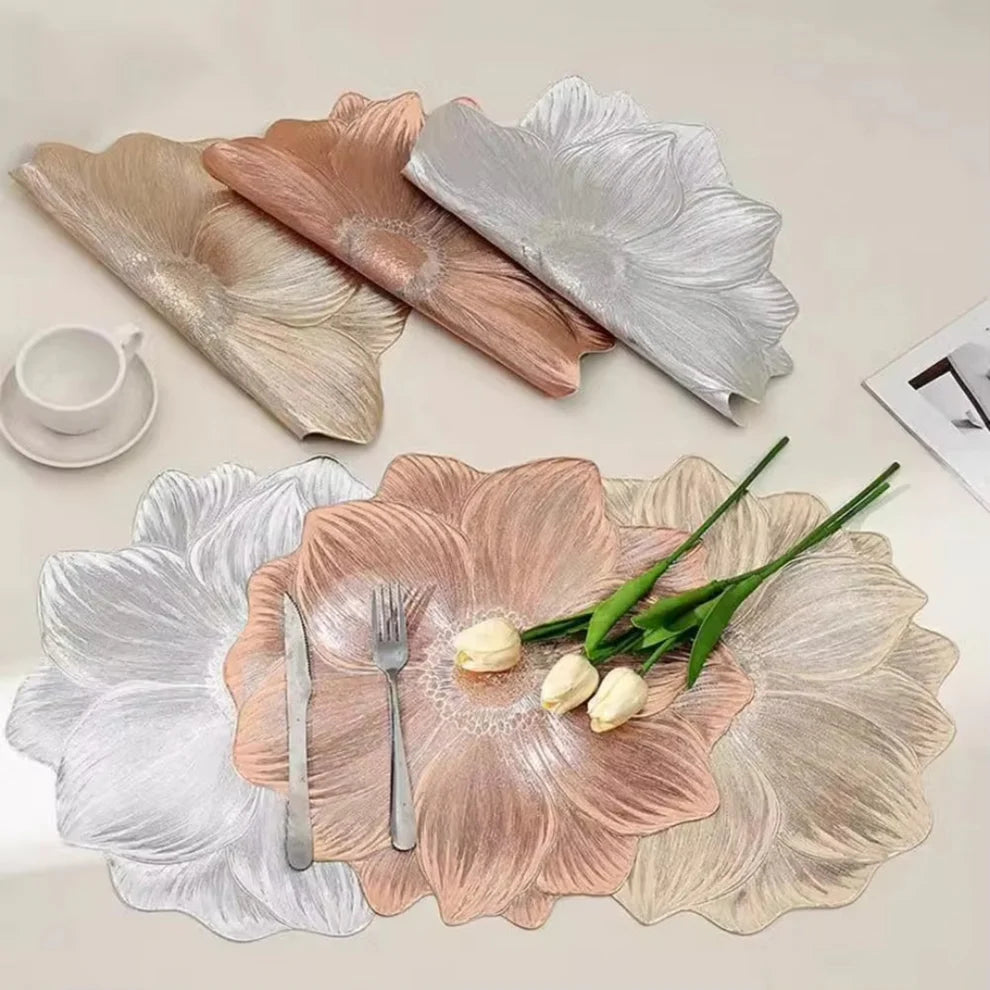 Floral-patterned placemats with cutlery and flowers on a table setting.