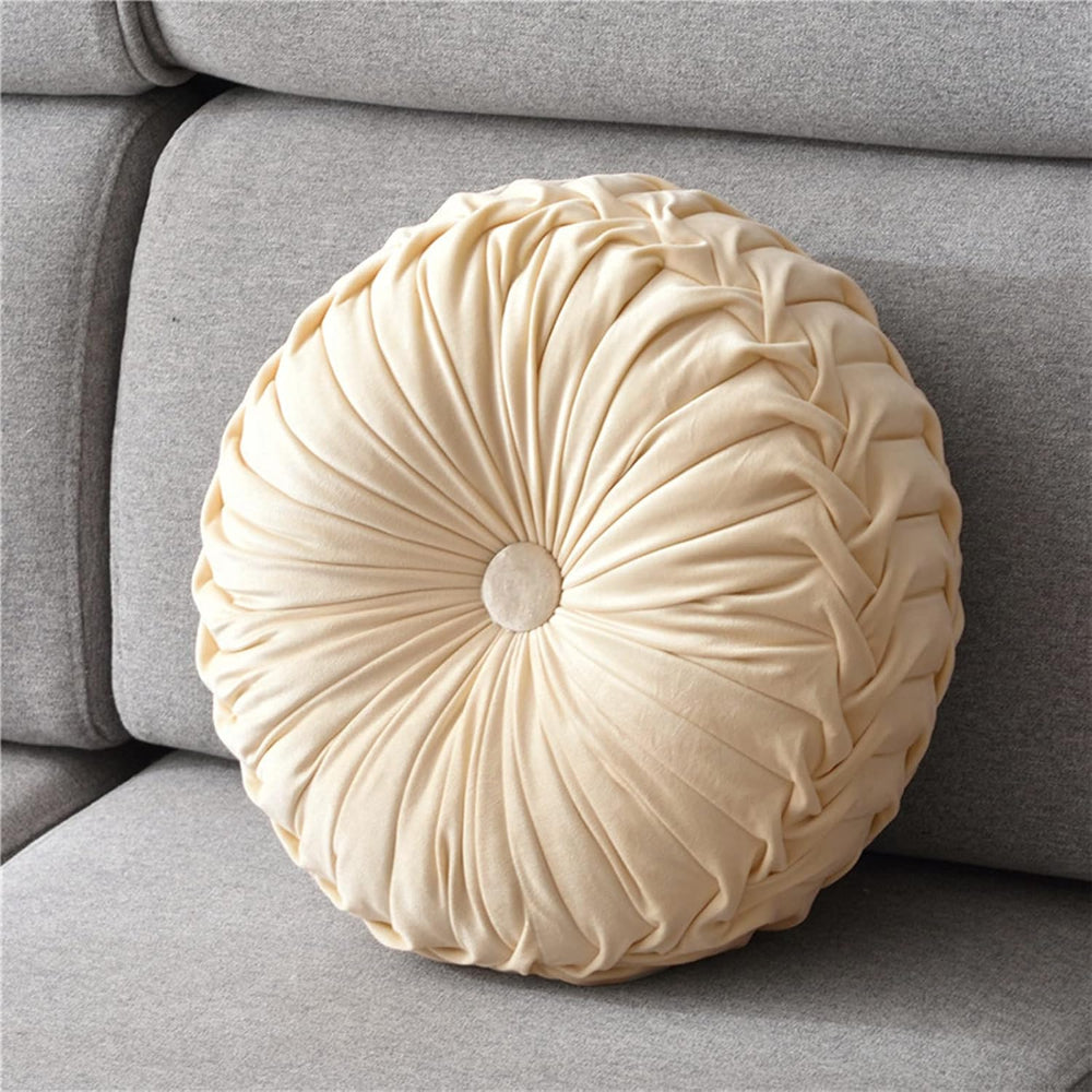 Round beige pillow on a gray sofa