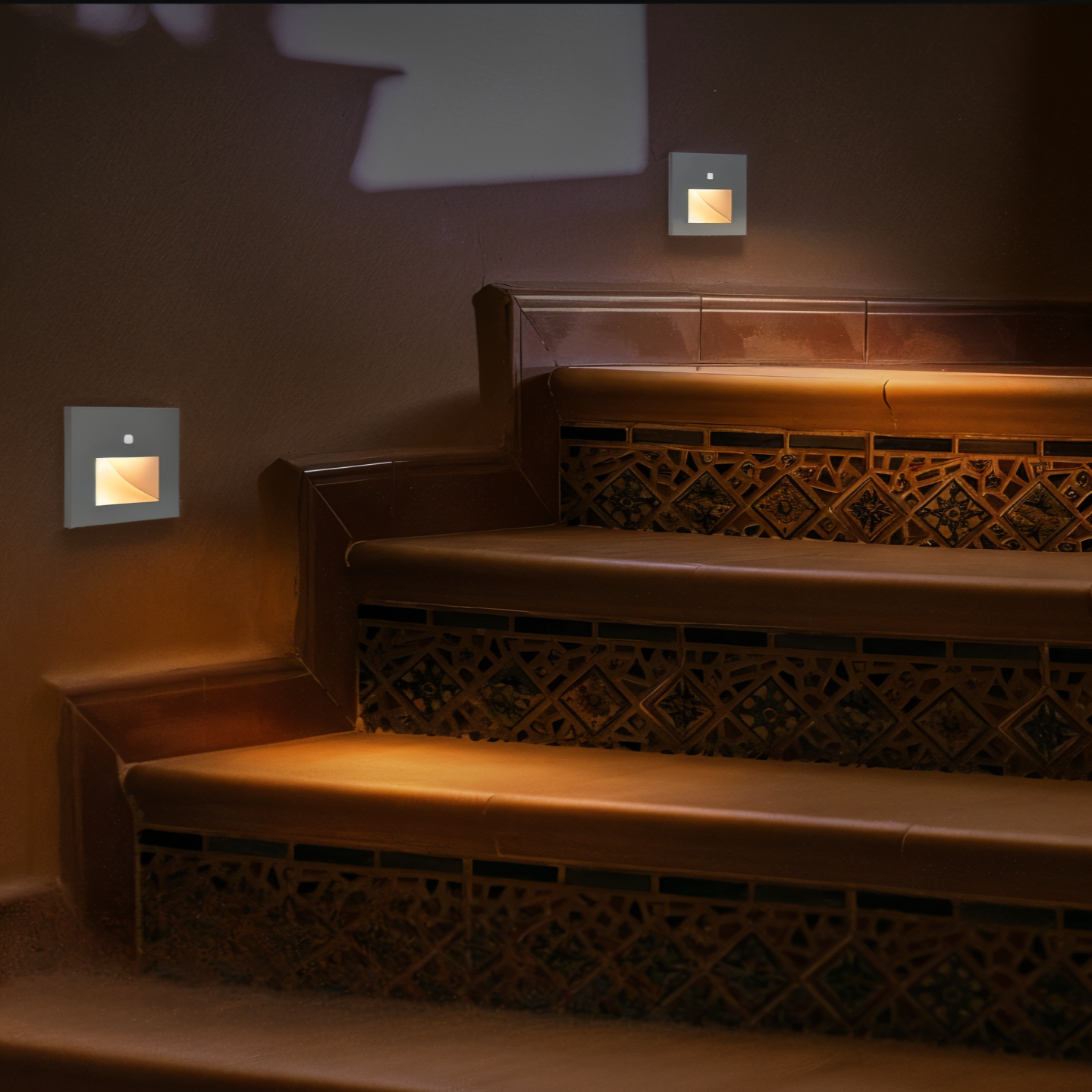 Staircase with wall-mounted lights casting a warm glow