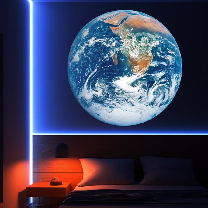 Large Earth model on a wall above a bed in a dimly lit room