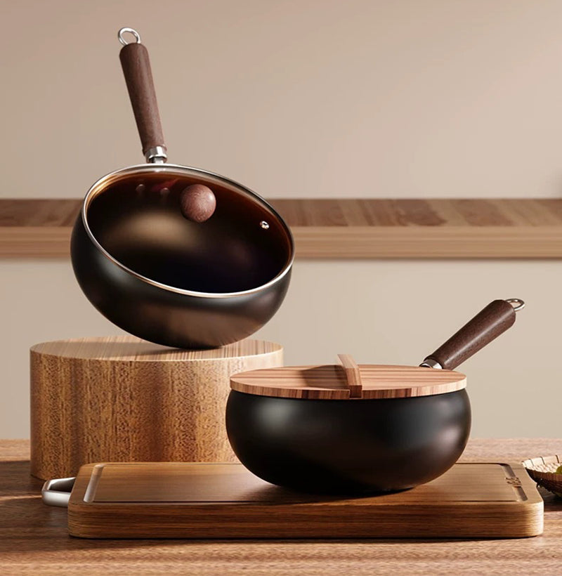 Black wok with wooden handle and lid on a wooden surface