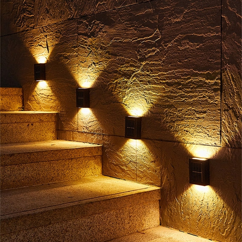 Staircase with stone walls and illuminated by wall-mounted lights