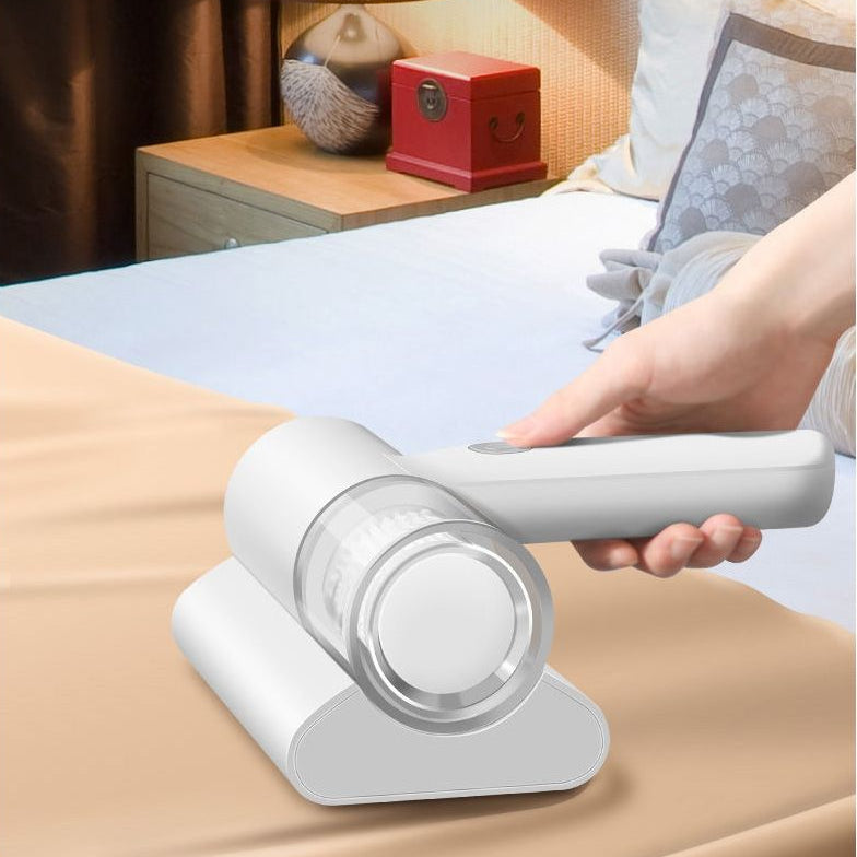 Handheld vacuum cleaner on a bed with a person using it