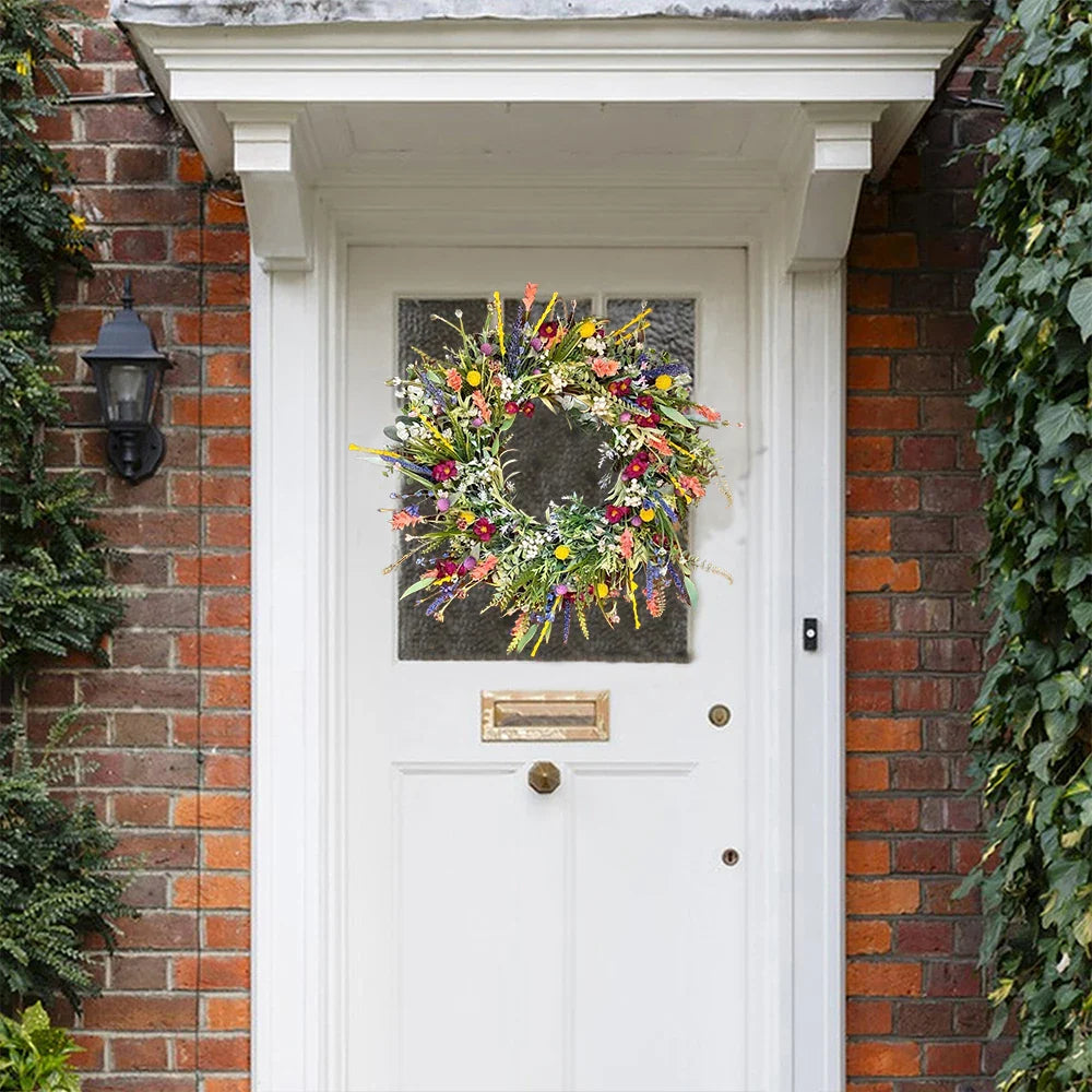 Decorative floral wreath on a white door with brick walls.