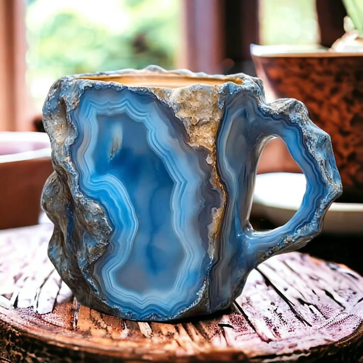 Blue agate stone shaped like a mug on a wooden surface
