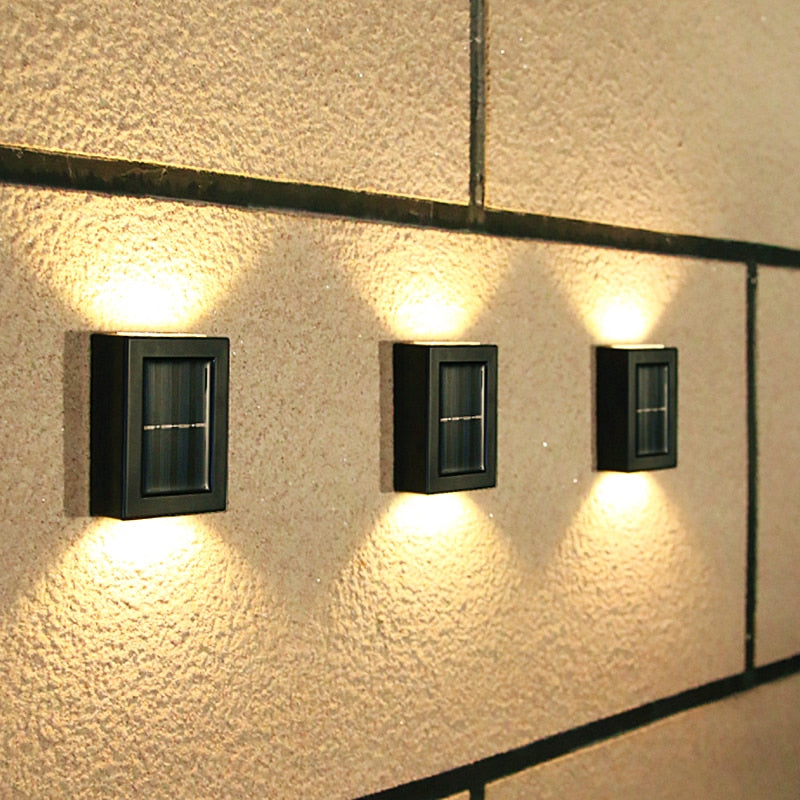 Three outdoor wall lights mounted on a textured wall.