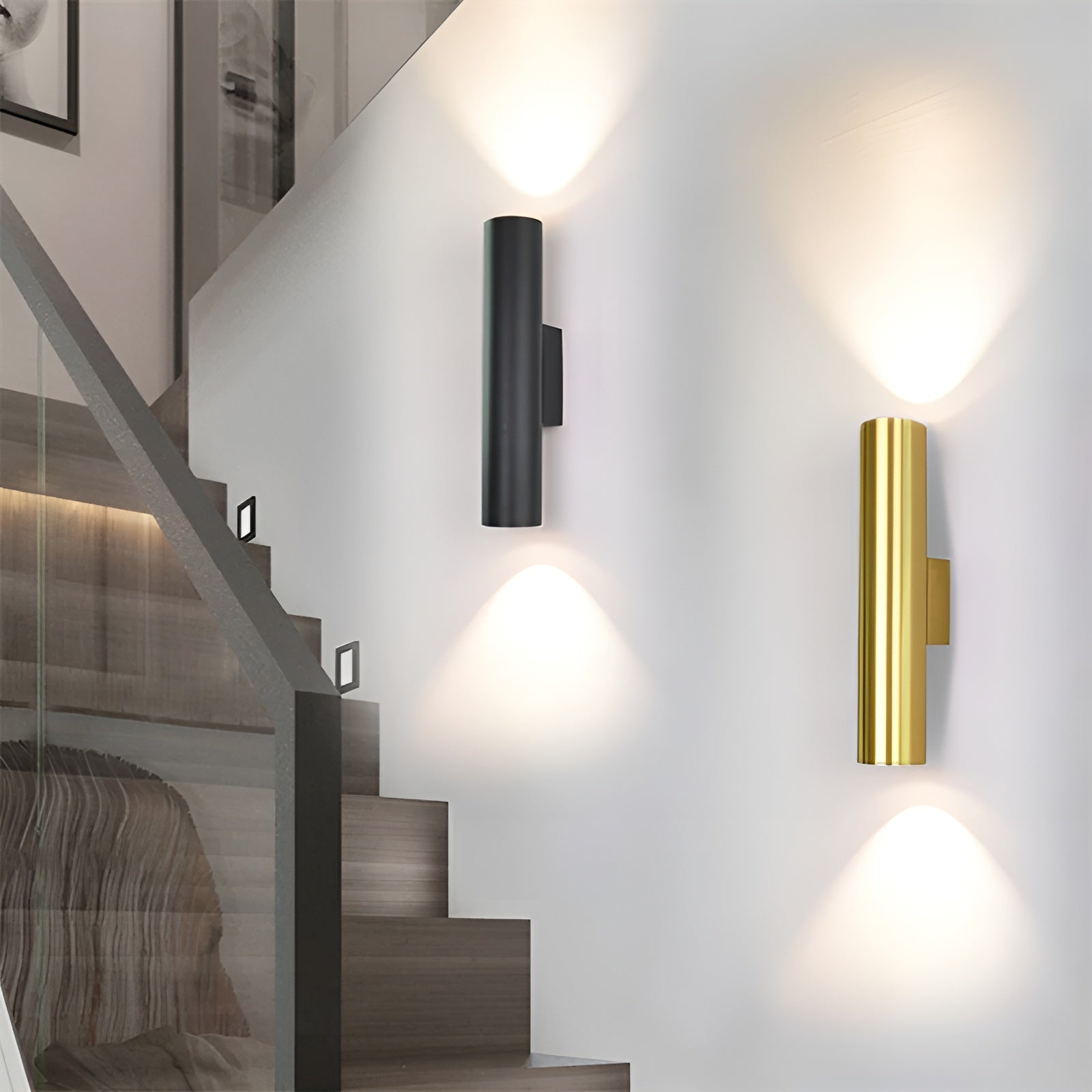 Two wall lights, one black and one gold, on a staircase wall.