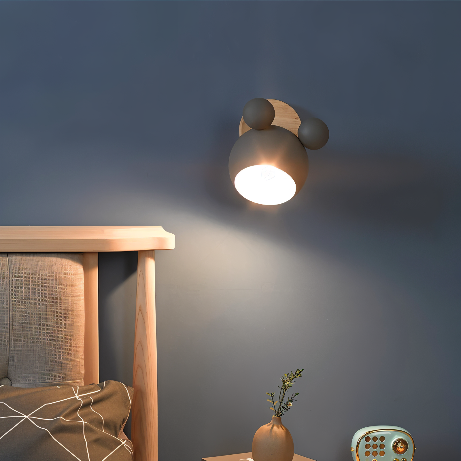 Modern wall lamp on a dark wall with a wooden headboard and decorative items.