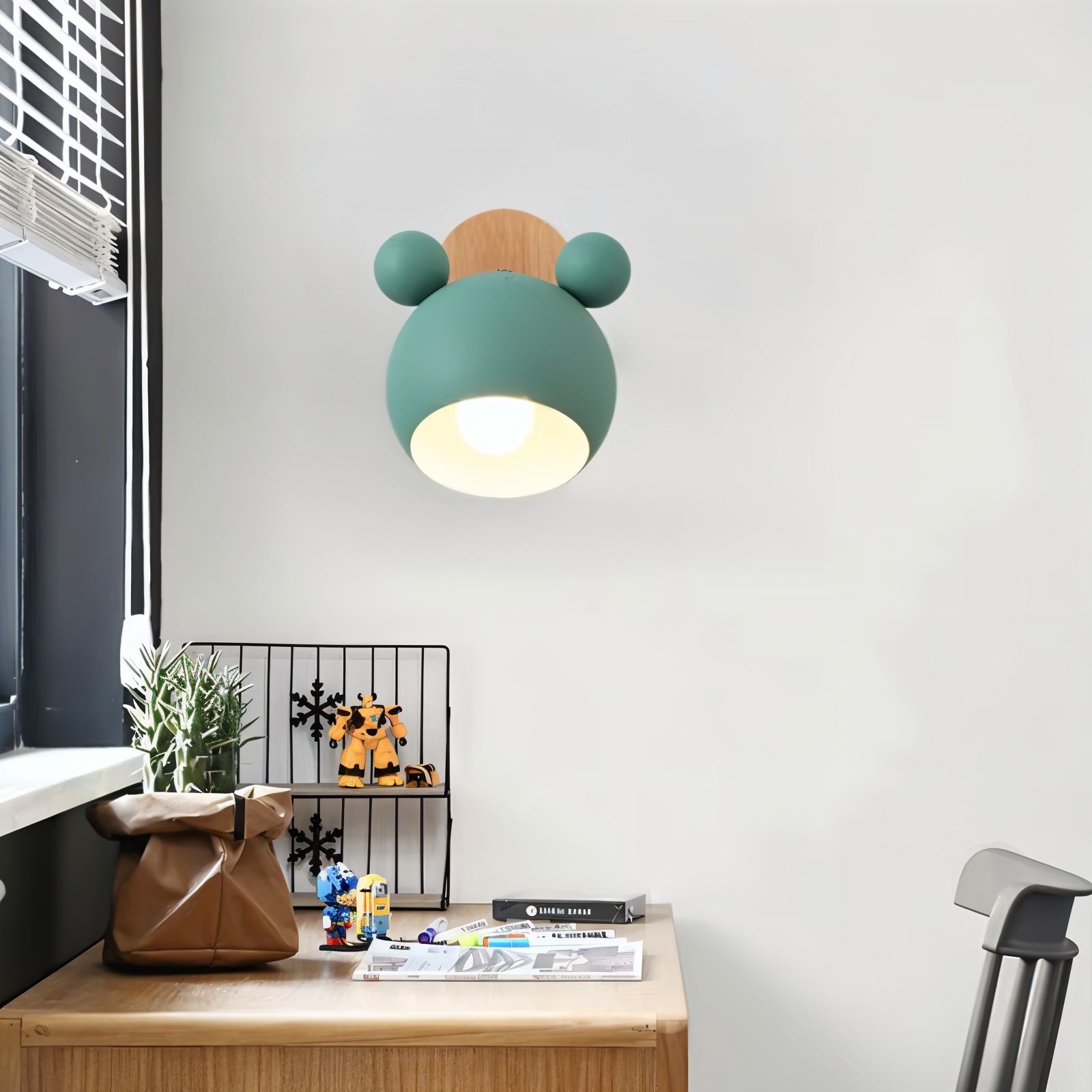Children's room with a green and brown teddy bear-shaped lamp on a desk.