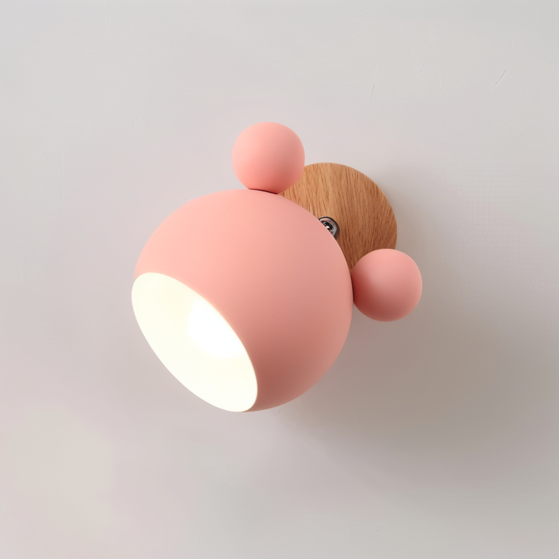 Pink wall light fixture with wooden base on a plain background