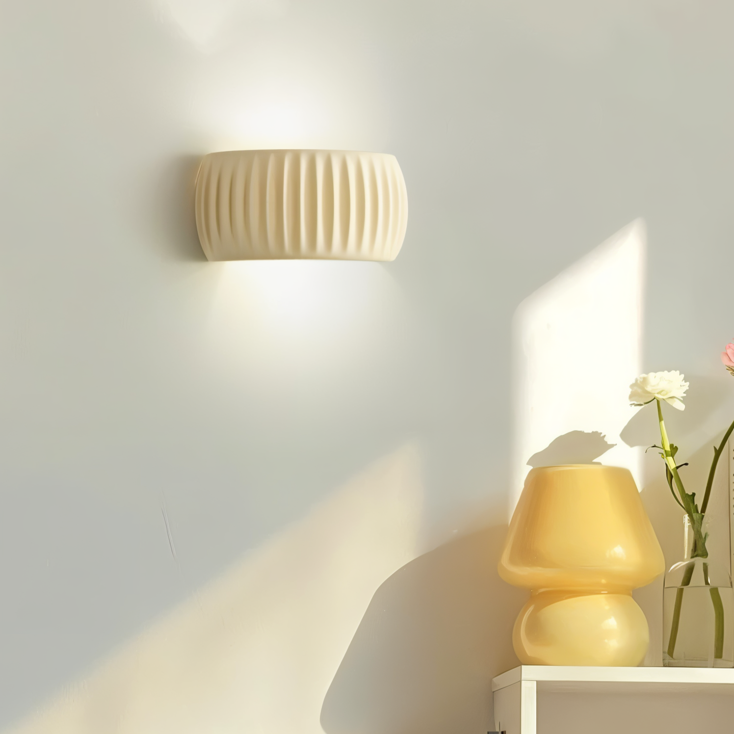 Wall-mounted light fixture casting a warm glow on a neutral wall with decorative items below.