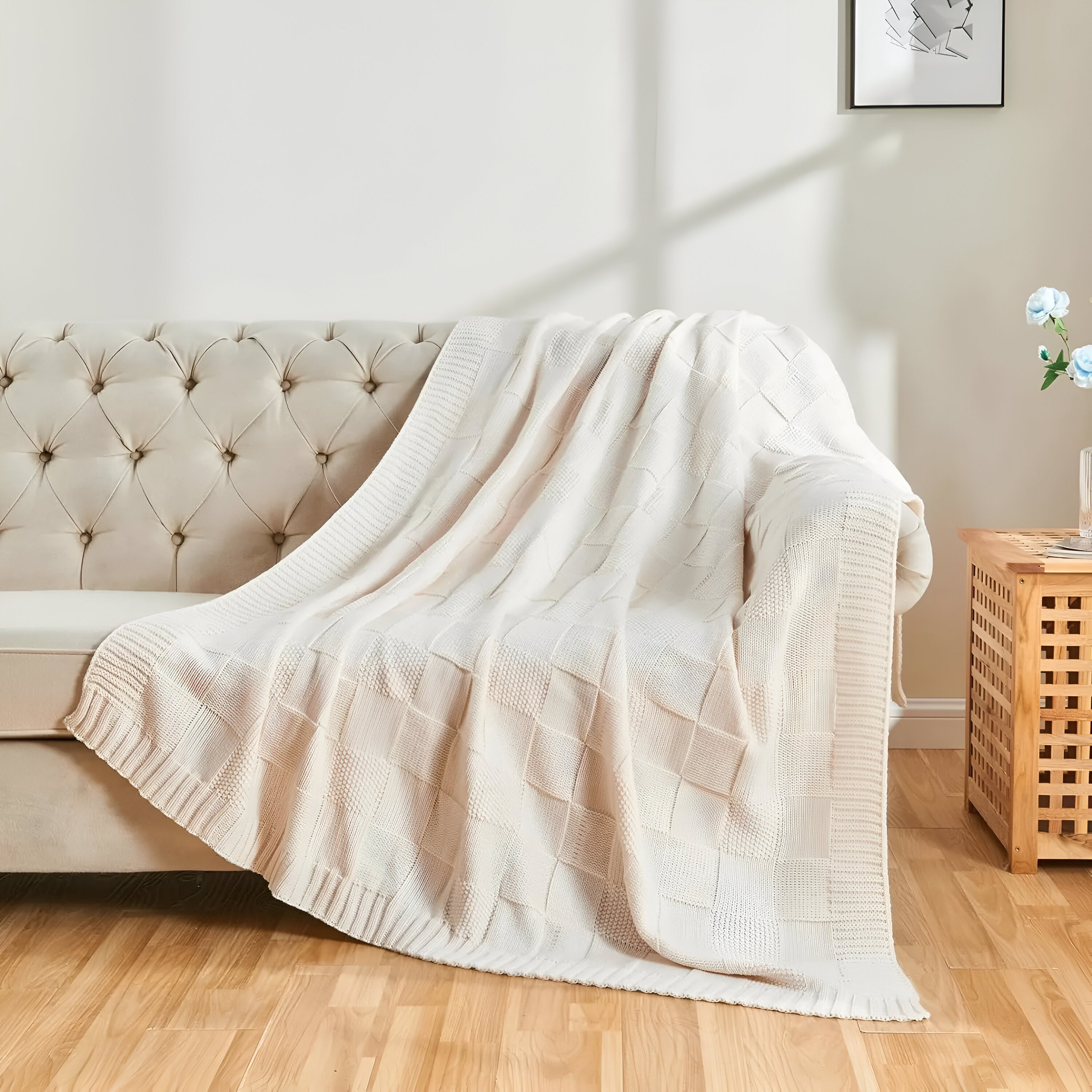 Beige blanket draped over a beige sofa in a living room setting.