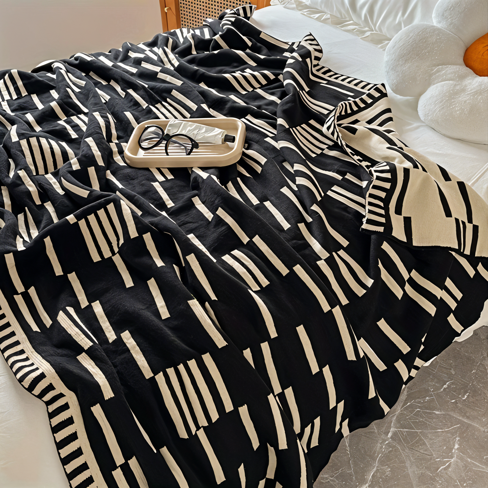 Black and white patterned blanket draped over a chair with a small tray on top.