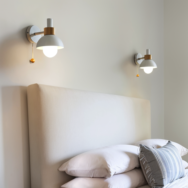 Two wall-mounted lights above a bed with white bedding and pillows.