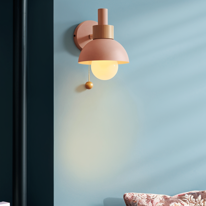 Wall-mounted lamp with a warm glow on a light blue wall.