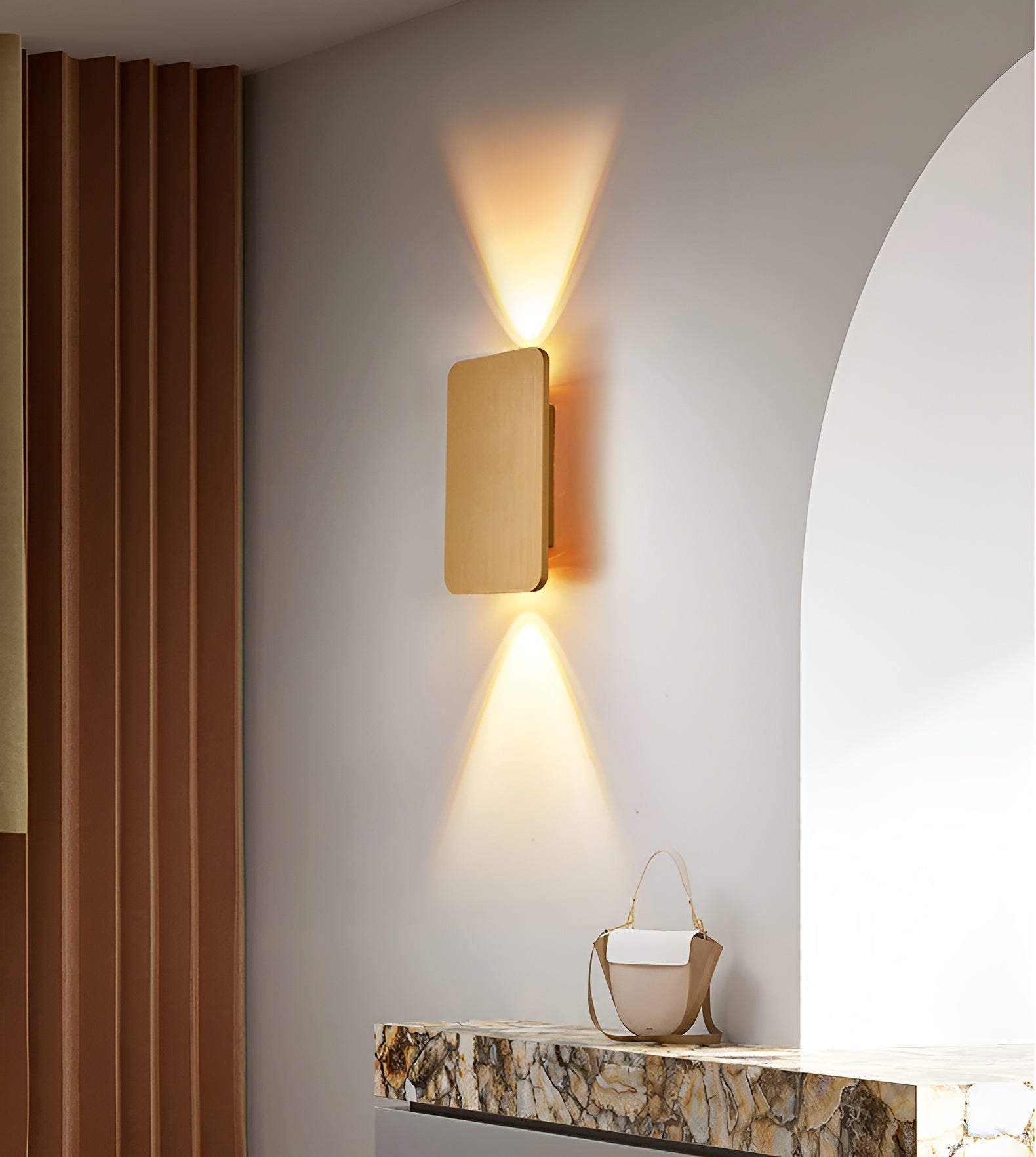 Modern wall light fixture on a neutral wall with a decorative shelf below.