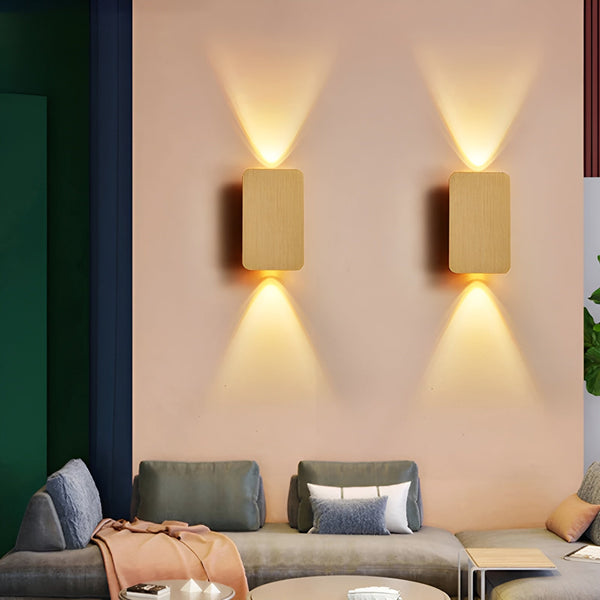 Two wall-mounted lights on a wall above a sofa in a living room.
