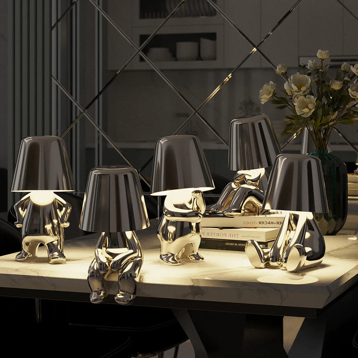 Set of four decorative table lamps with black and gold finishes on a marble surface.