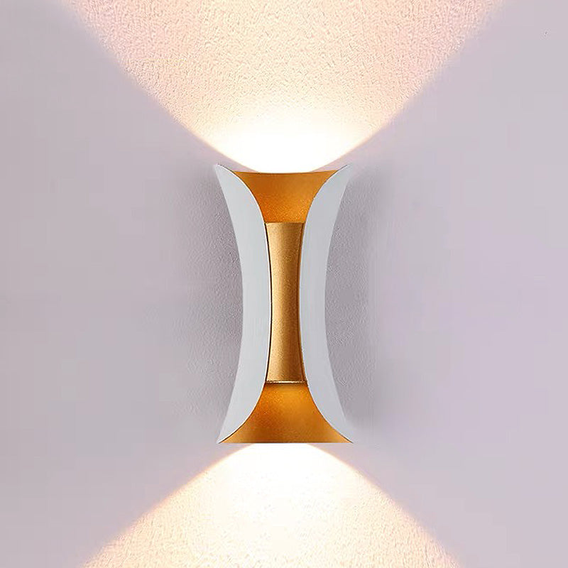 Modern wall lamp with gold and white design on a light gray wall