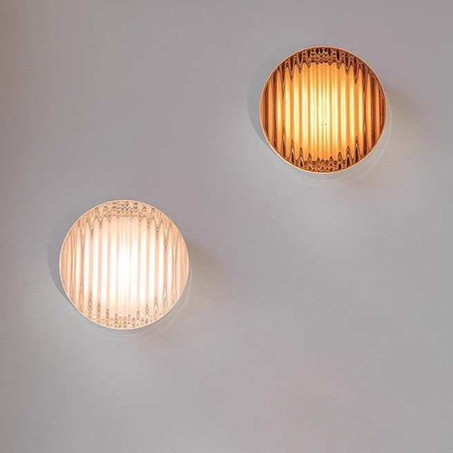Two Round wall light fixture on a textured wall