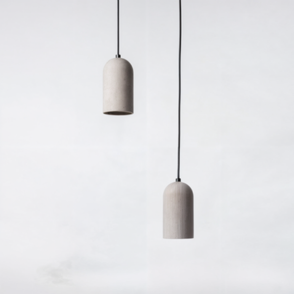 Two concrete pendant lights hanging against a white background