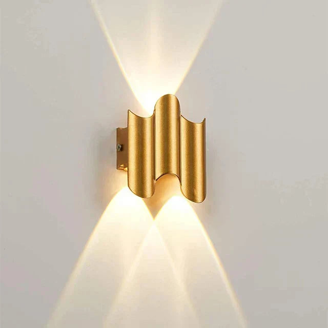 Gold wall-mounted light fixture on a white wall
