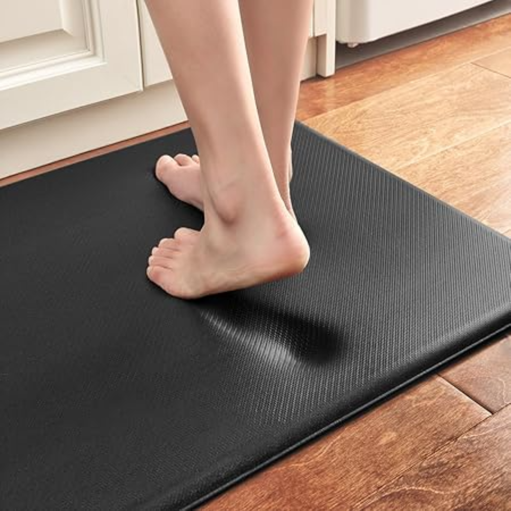 Person stepping onto a black anti-fatigue mat in a kitchen.