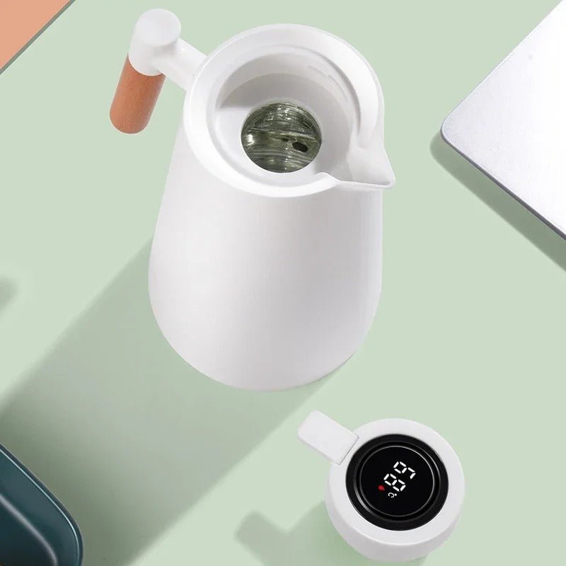 White electric kettle with a digital temperature display on a light green surface