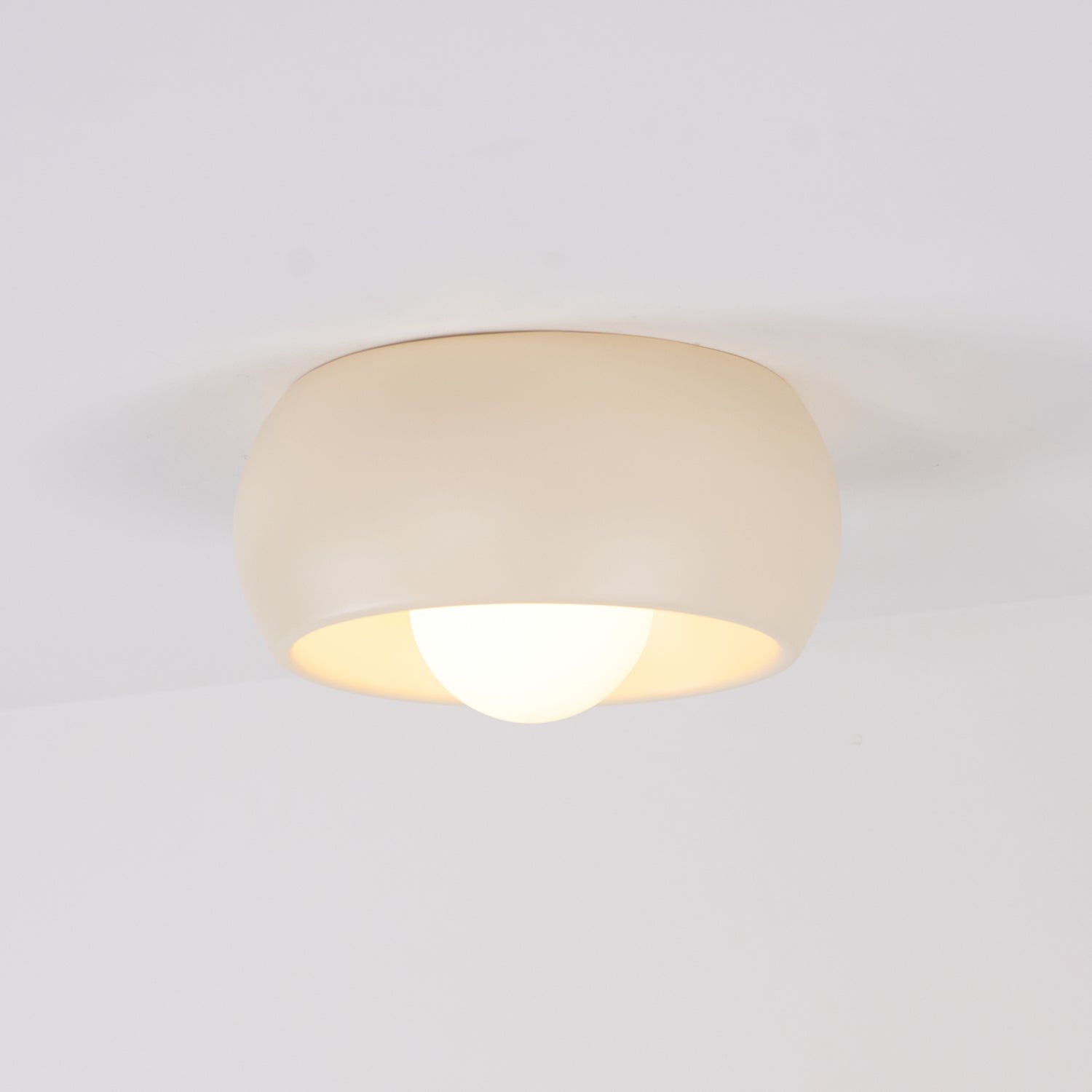 Ceiling light fixture with beige shade on a white background