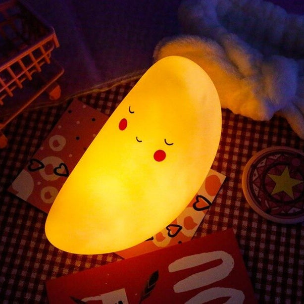Moon-shaped night light on a checkered blanket with a soft focus background
