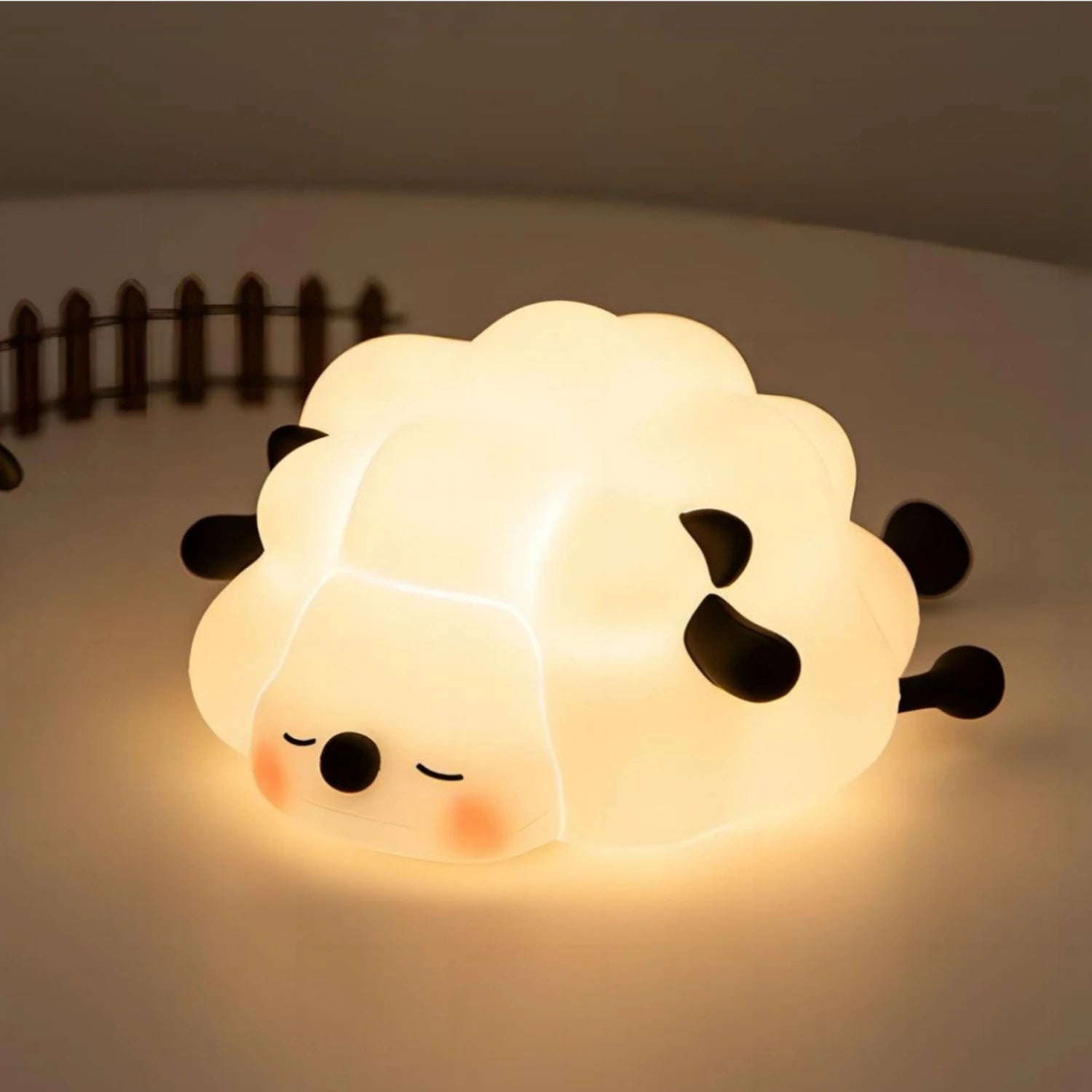 Cute sheep-shaped night light on a soft surface with a blurred background