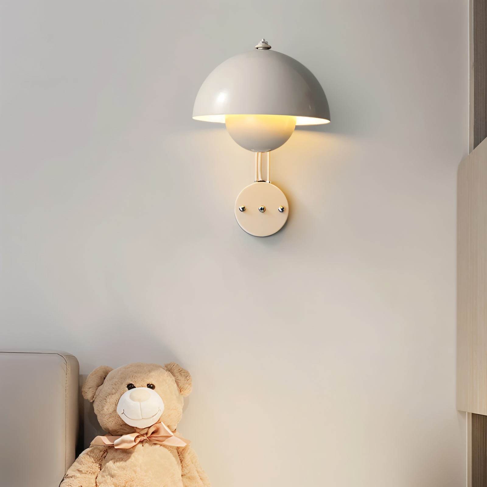Wall lamp with a face design next to a teddy bear on a light gray wall.