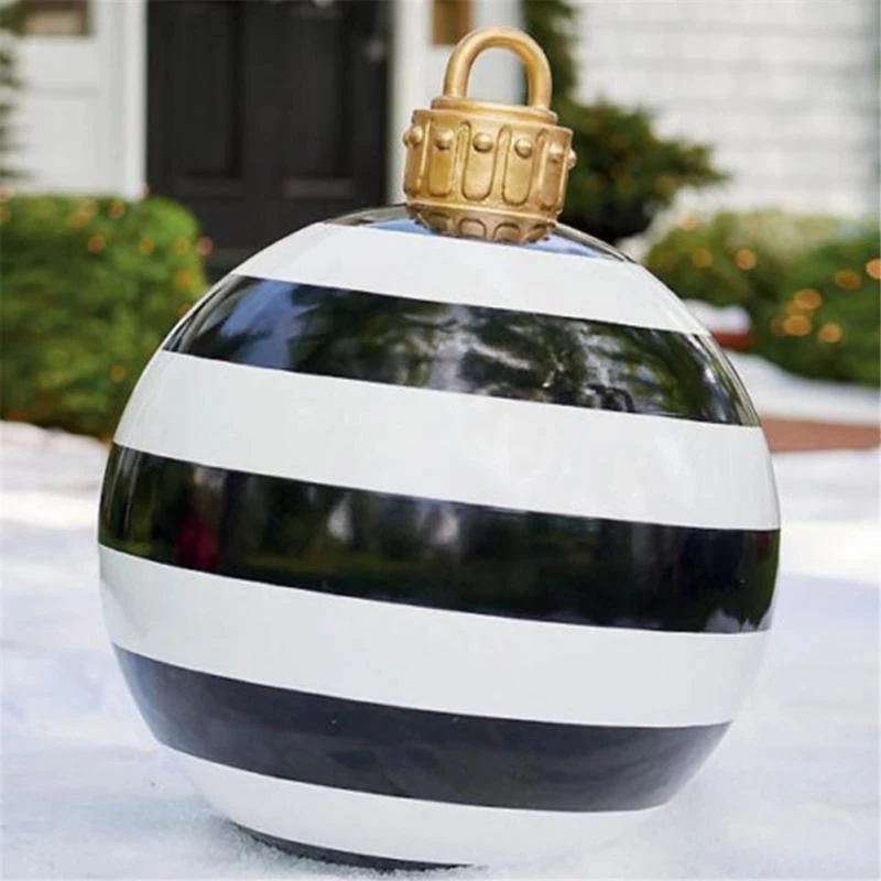 Decorative ornament with black and white stripes and a gold top on a snowy background