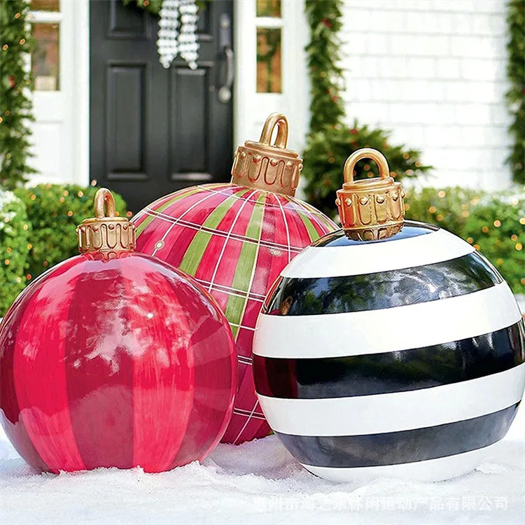 Decorative Christmas ornaments in red, green, and black and white stripes on a snowy surface.