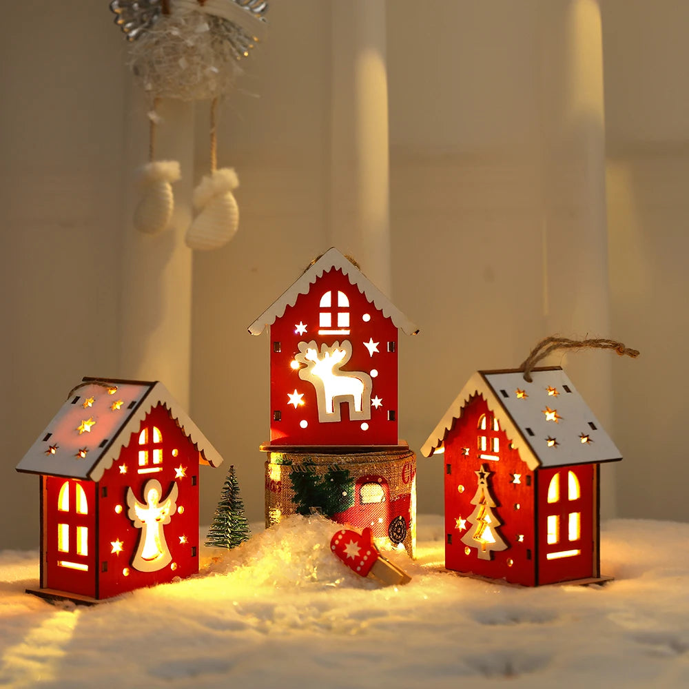 Three decorative LED houses with Christmas-themed designs on a snowy background.
