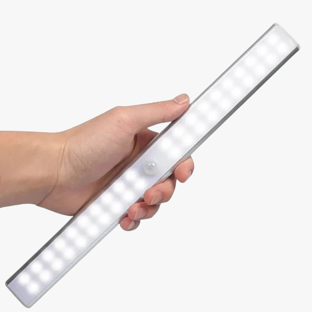 Hand holding a long, thin LED light bar on a white background