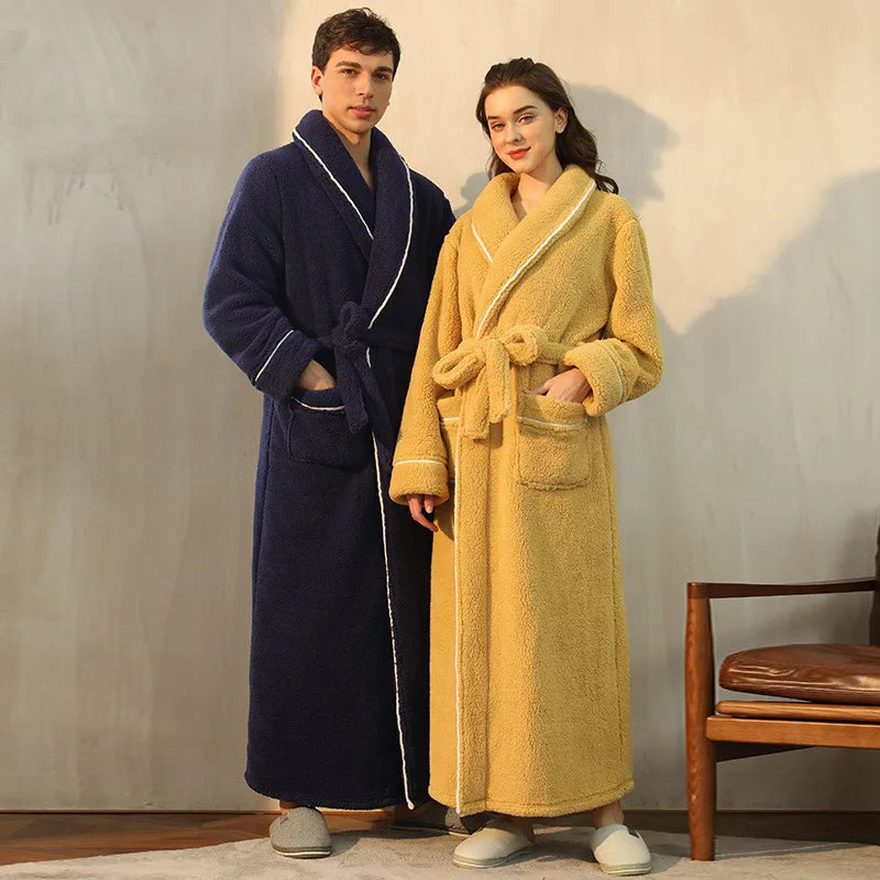 Two people wearing long robes, one navy and one yellow, standing against a plain wall.